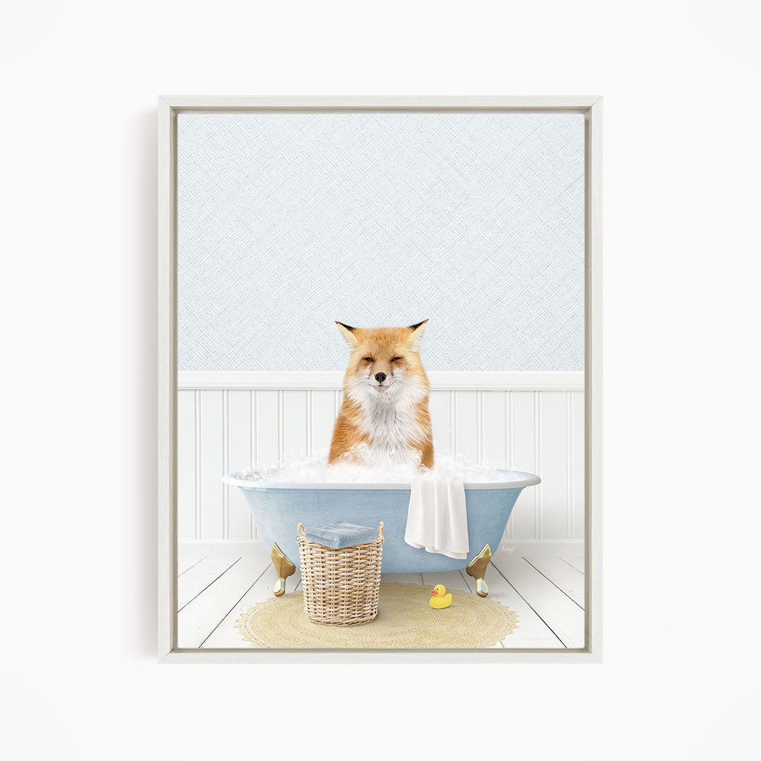 A red fox is sitting in a blue bathtub filled with bubbles, surrounded by a yellow rubber duck and a white basket.