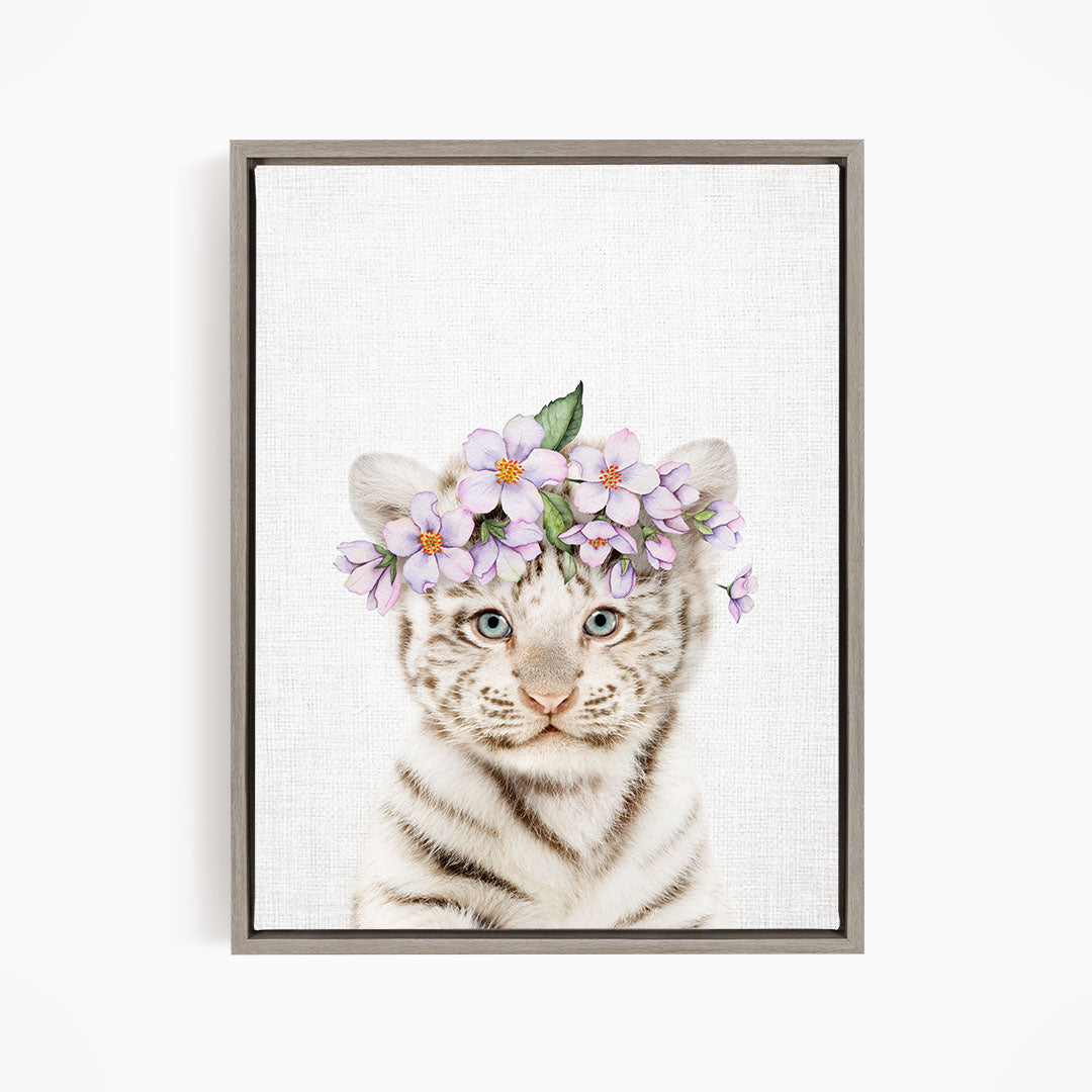 A young tiger cub wearing a floral headpiece with purple flowers.