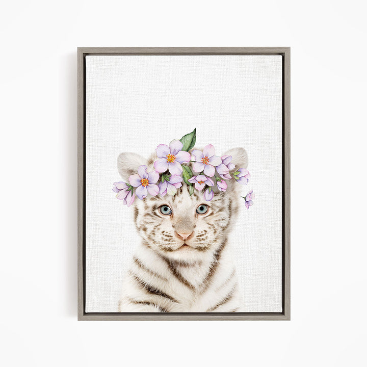 A young tiger cub wearing a floral headpiece with purple flowers.
