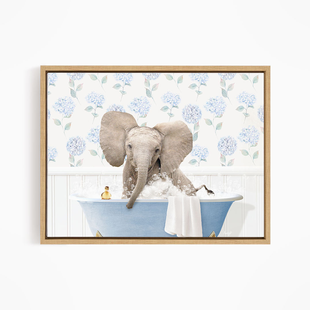A gray elephant is sitting in a blue bathtub filled with water, surrounded by a floral patterned wall.