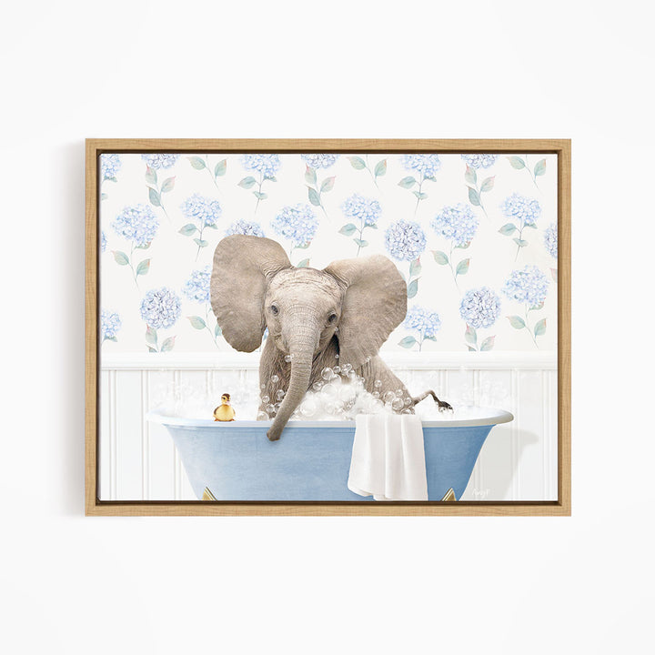 A gray elephant is sitting in a blue bathtub filled with water, surrounded by a floral patterned wall.