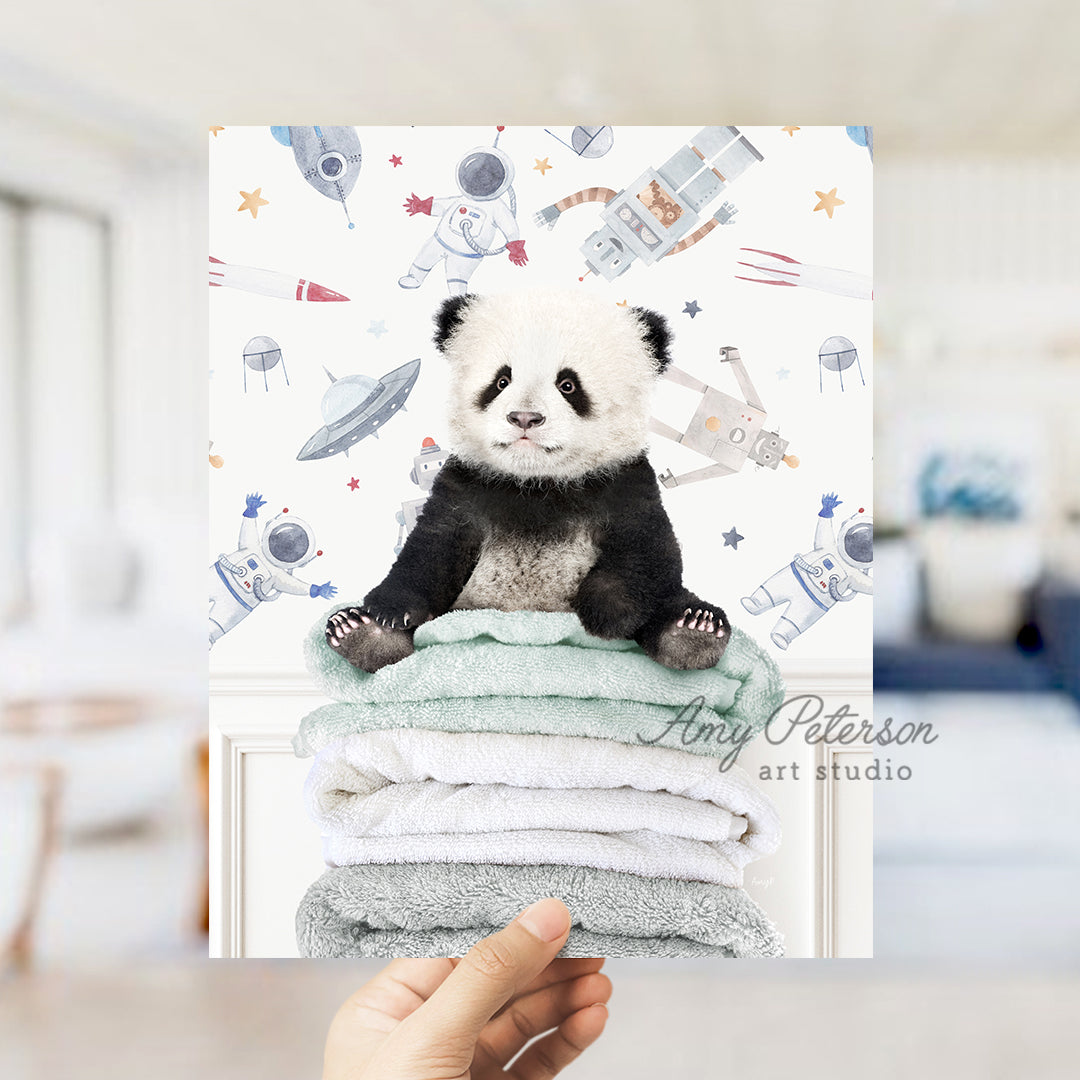 a panda bear sitting on top of a pile of towels