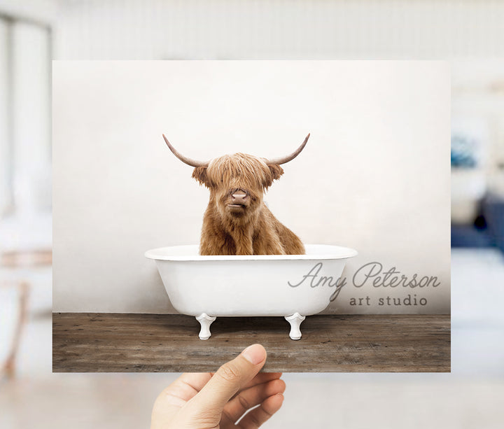 a hand holding up a card with a picture of a bull in a bathtub