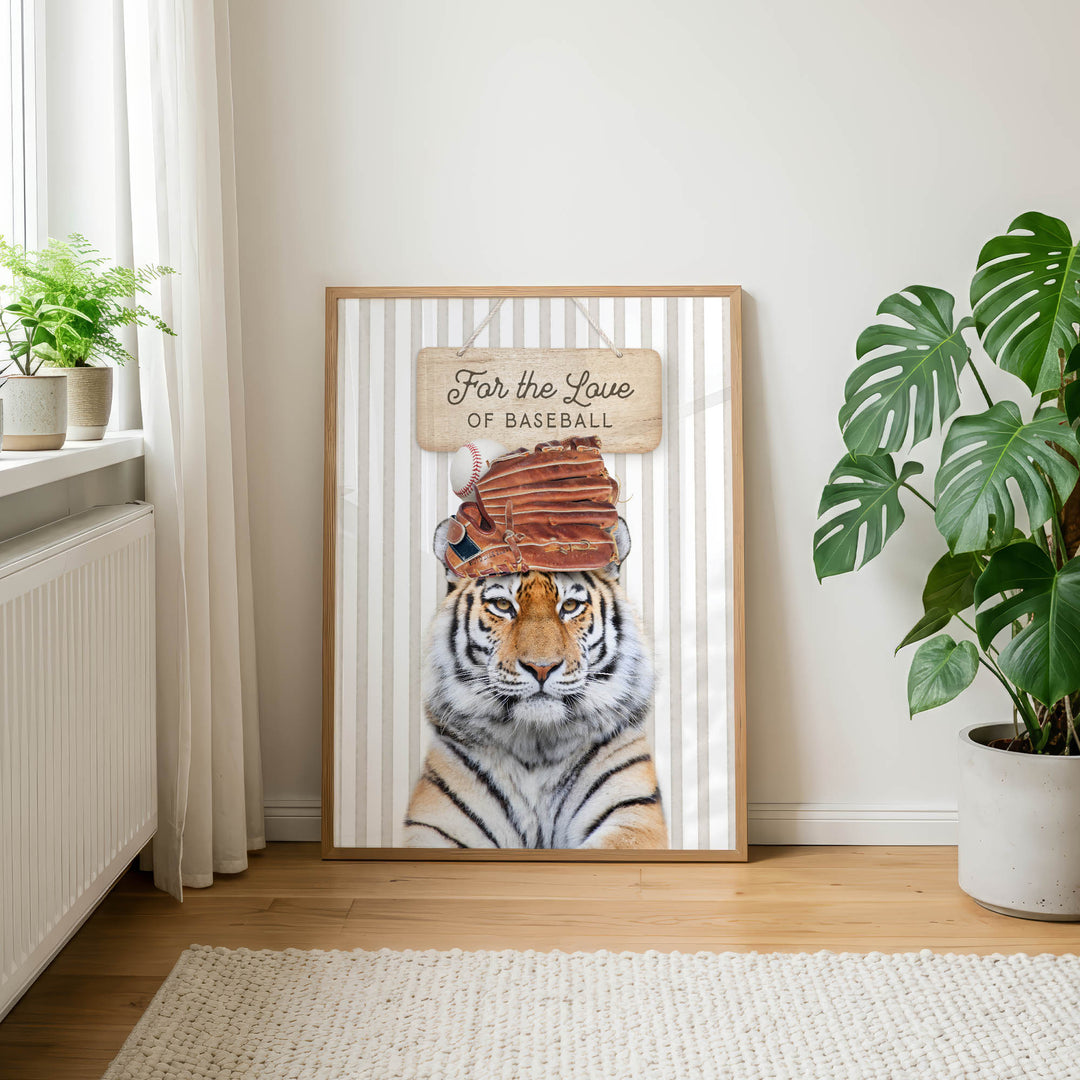 A framed poster of a tiger wearing a baseball cap with the text "For the Love of Baseball" is displayed on a wall in a room with a rug and potted plants.