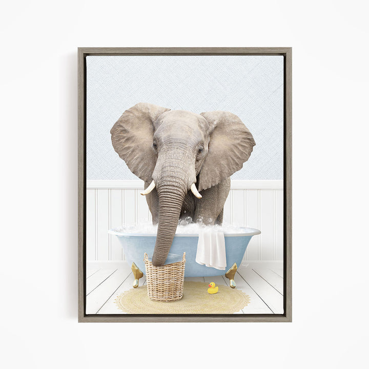 A gray elephant is standing in a blue bathtub filled with water, surrounded by a yellow rubber duck and a basket.