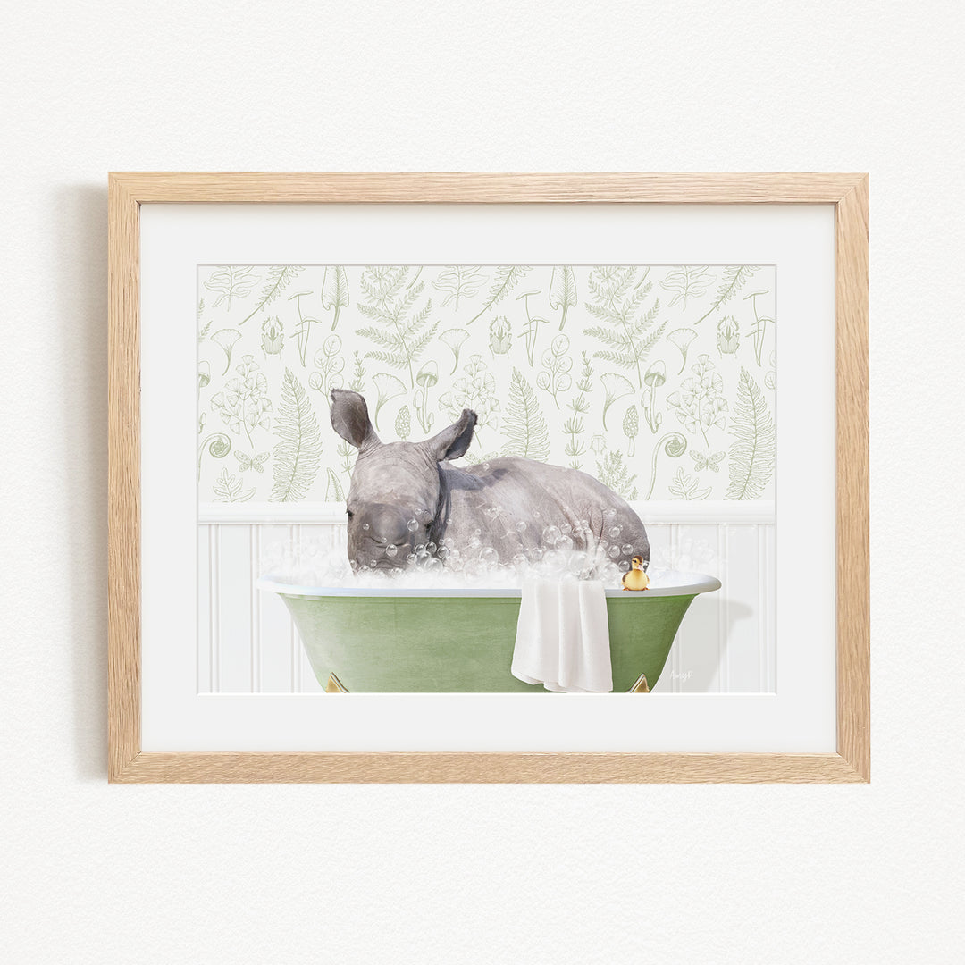 A rhinoceros is sitting in a green bathtub filled with water, surrounded by a white and green floral pattern.