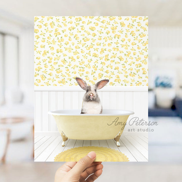 a person holding up a picture of a bunny in a bathtub