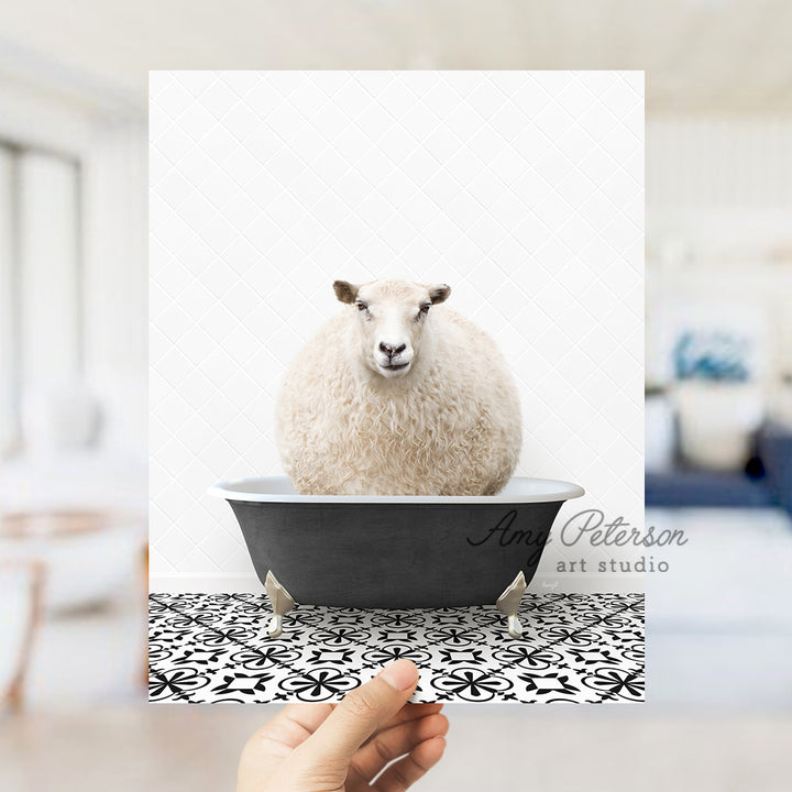 a hand holding a card with a sheep in a bathtub