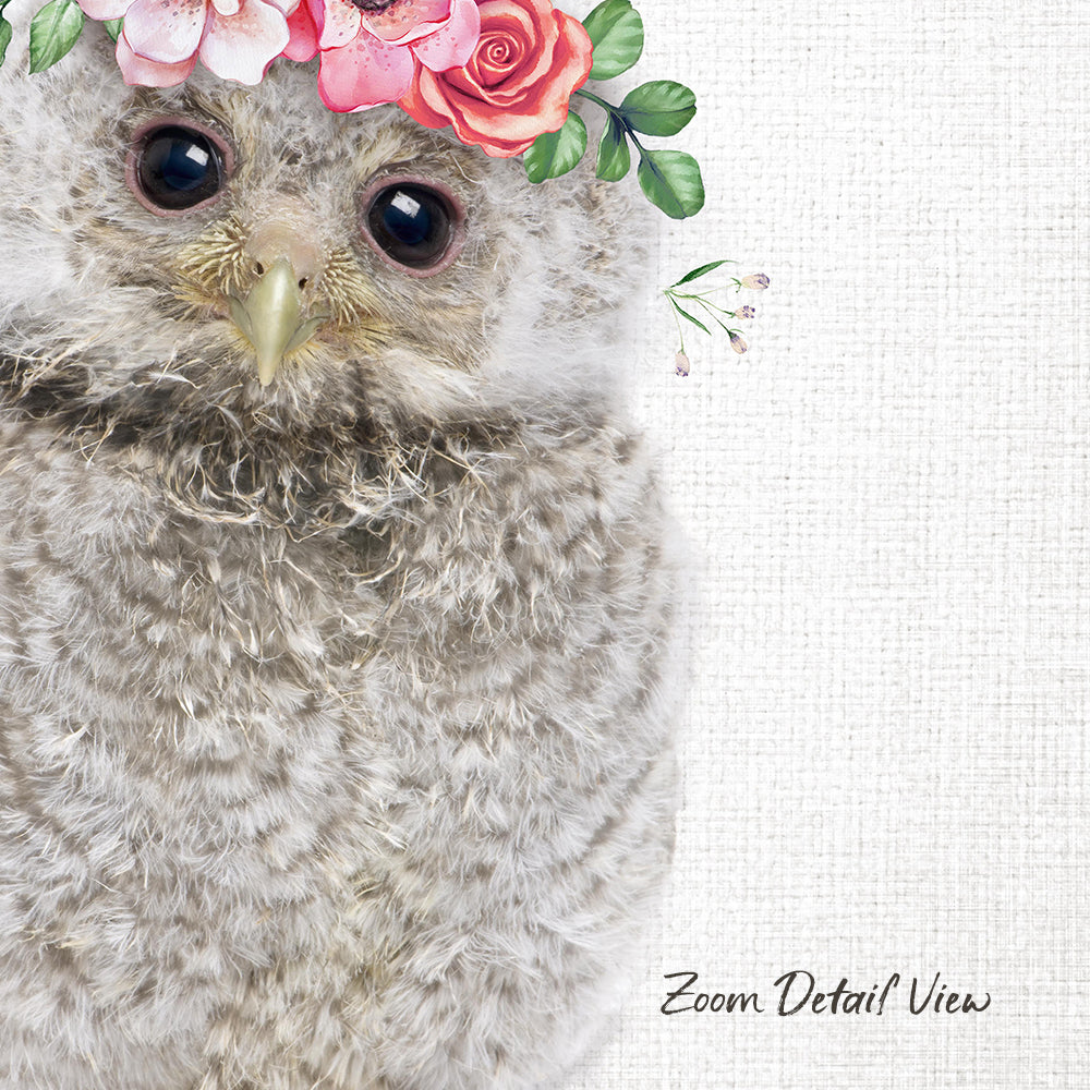 A close-up of a fluffy gray owl wearing a floral crown of pink and red flowers, with its eyes gently closed.