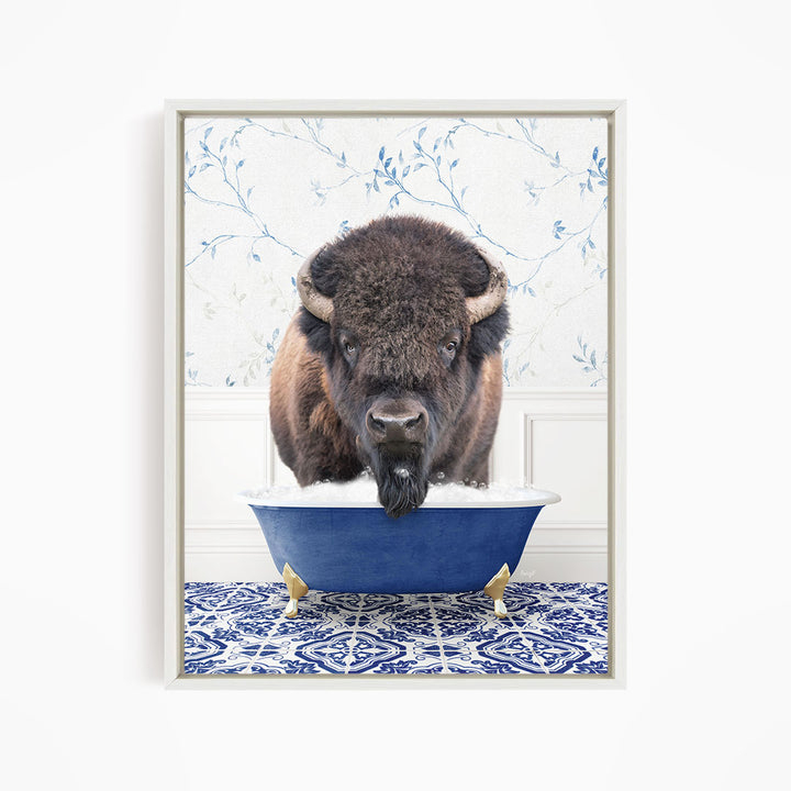 A buffalo with a long, shaggy mane is standing in a blue bathtub filled with water, with a patterned tile floor beneath it.