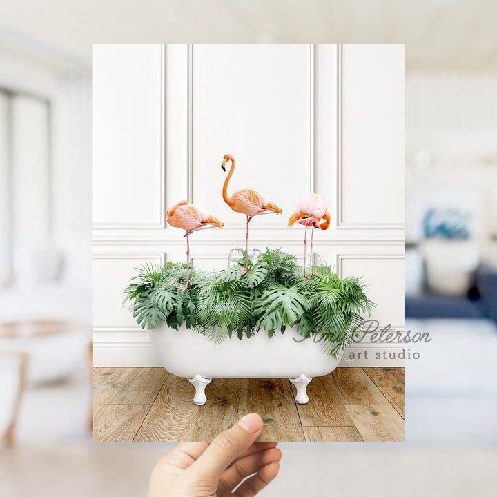 a hand holding a card with three flamingos in a bathtub