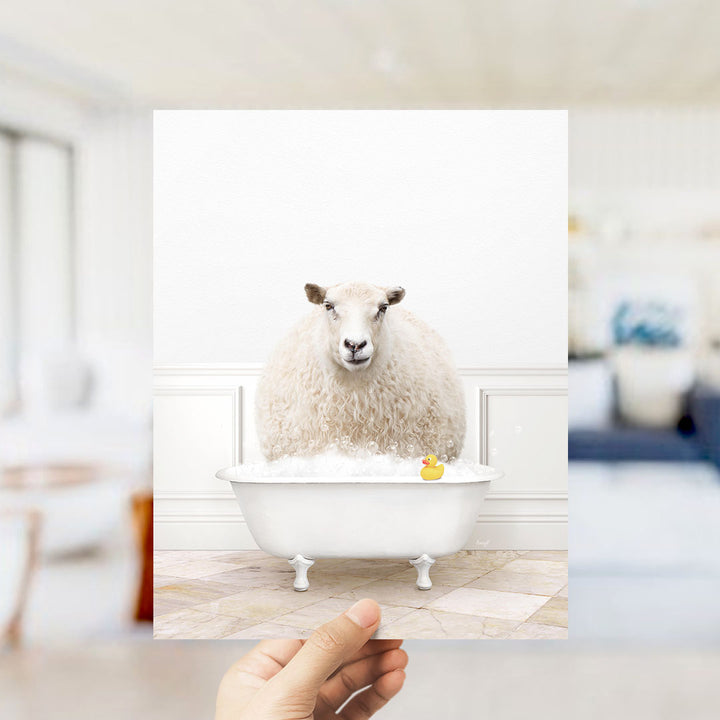 A fluffy white sheep sits in a white bathtub filled with bubbles, with a yellow rubber duck floating in the water.