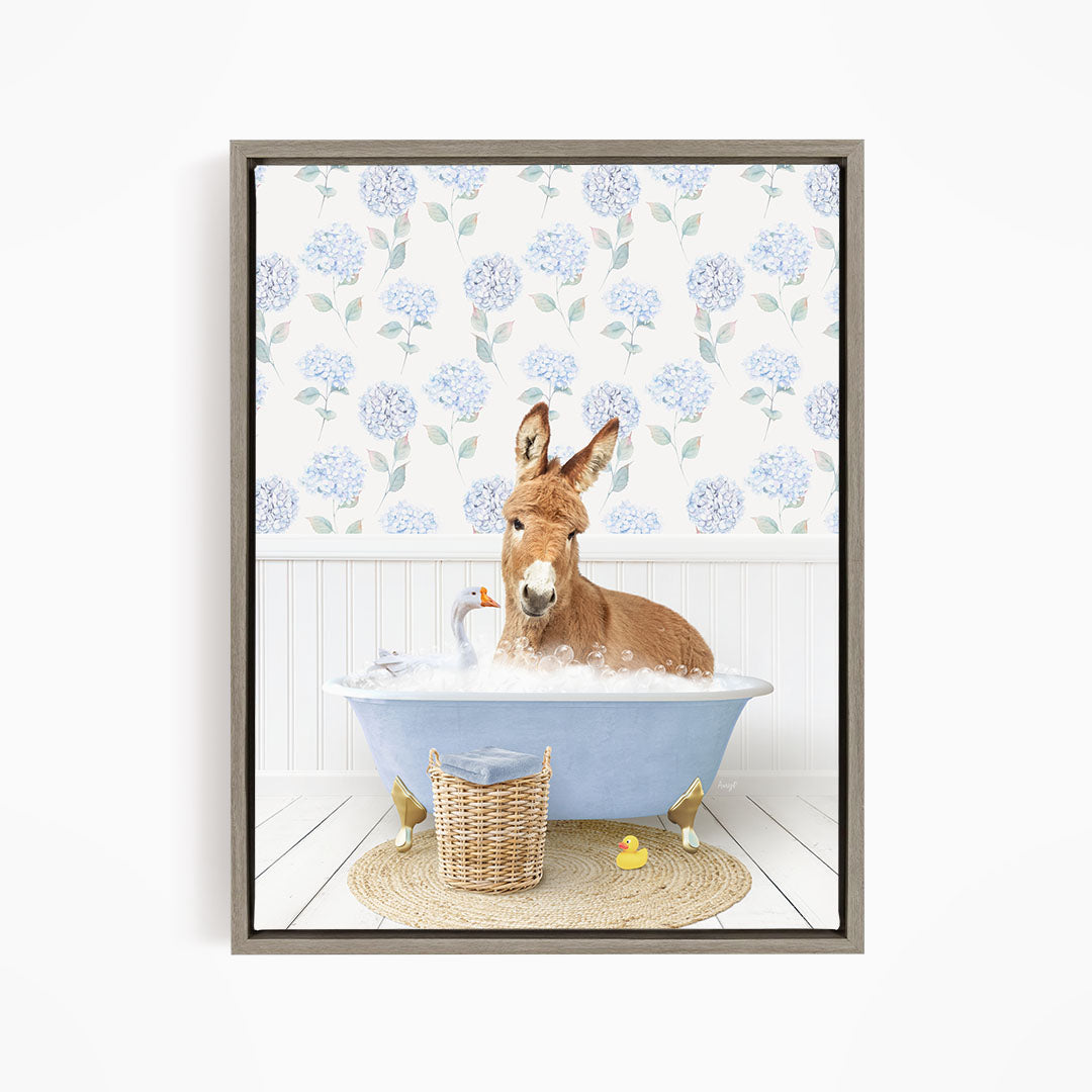 A donkey is sitting in a blue bathtub filled with water, surrounded by a basket of toys and a yellow rubber duck.