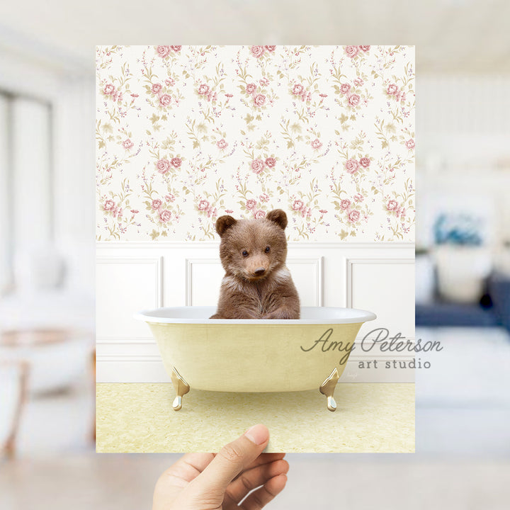 a person holding up a card with a teddy bear in a bathtub