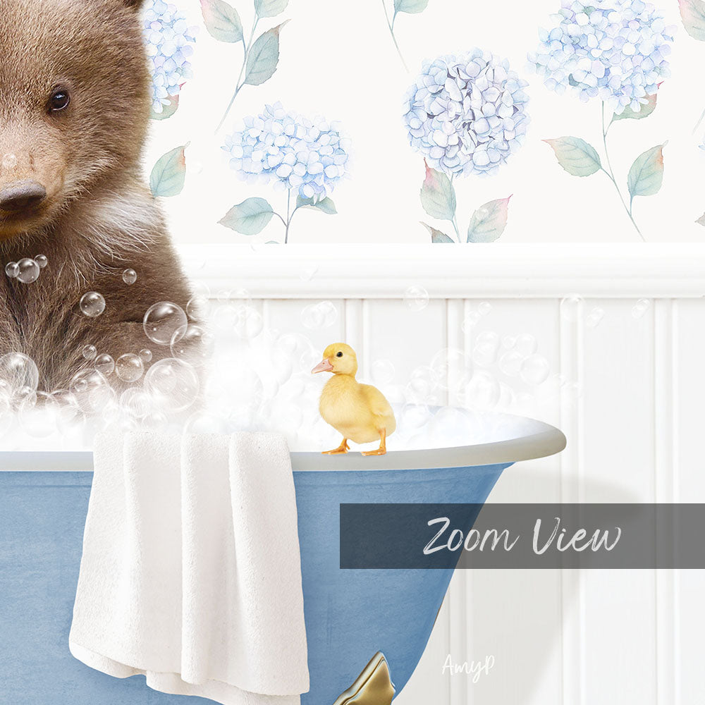 A brown bear is sitting in a blue bathtub filled with bubbles, with a yellow duck standing on the edge of the tub.