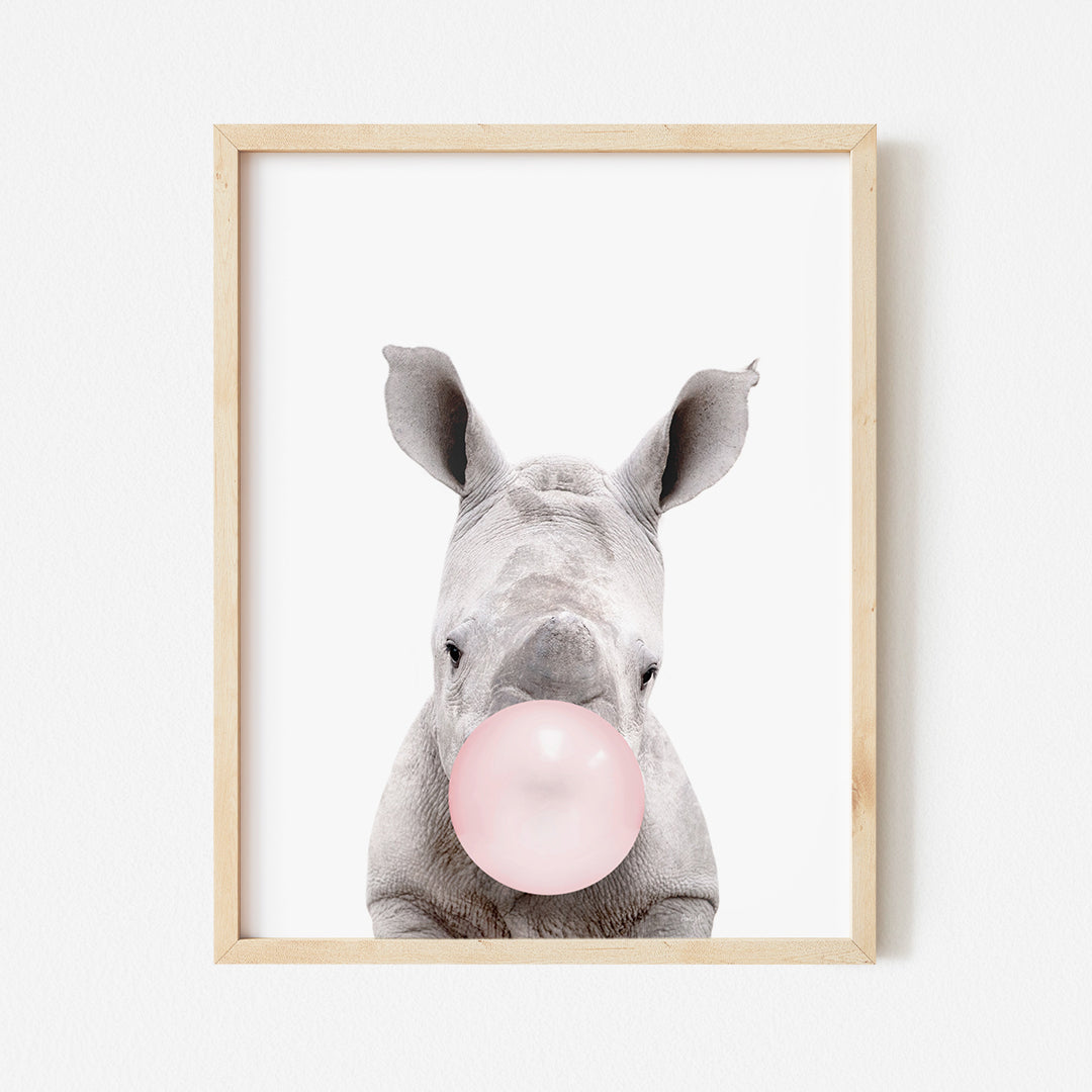 a picture of a baby rhino chewing on a pink bubble