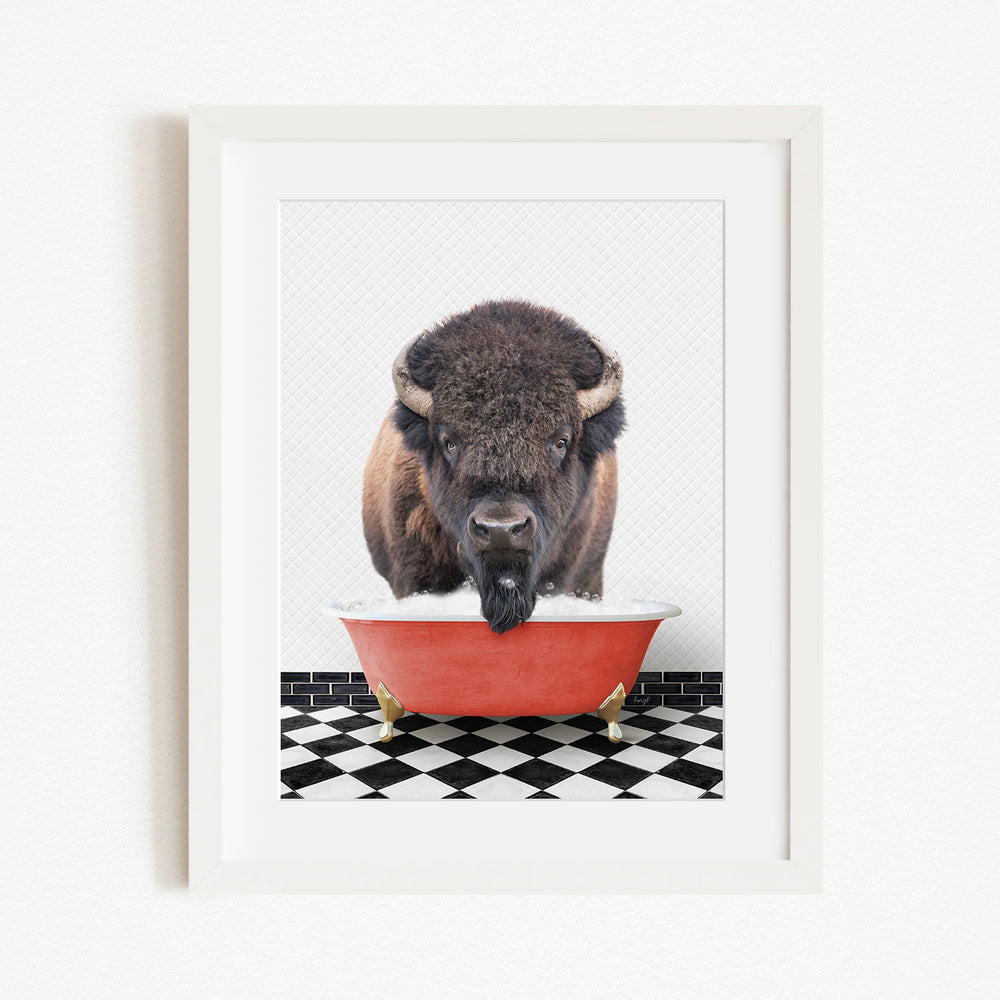 A buffalo with large horns is standing in a red bathtub, with a black and white checkered floor beneath it.