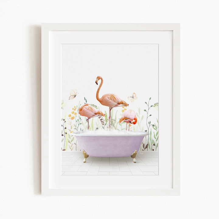 A framed illustration depicting three flamingos standing in a bathtub filled with bubbles, surrounded by a garden-like setting with flowers and butterflies.