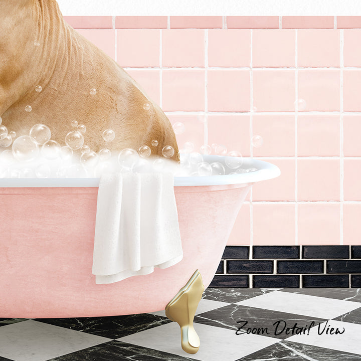 A dog is sitting in a pink bathtub filled with bubbles, with a white towel hanging on the side and a pink tile wall in the background.