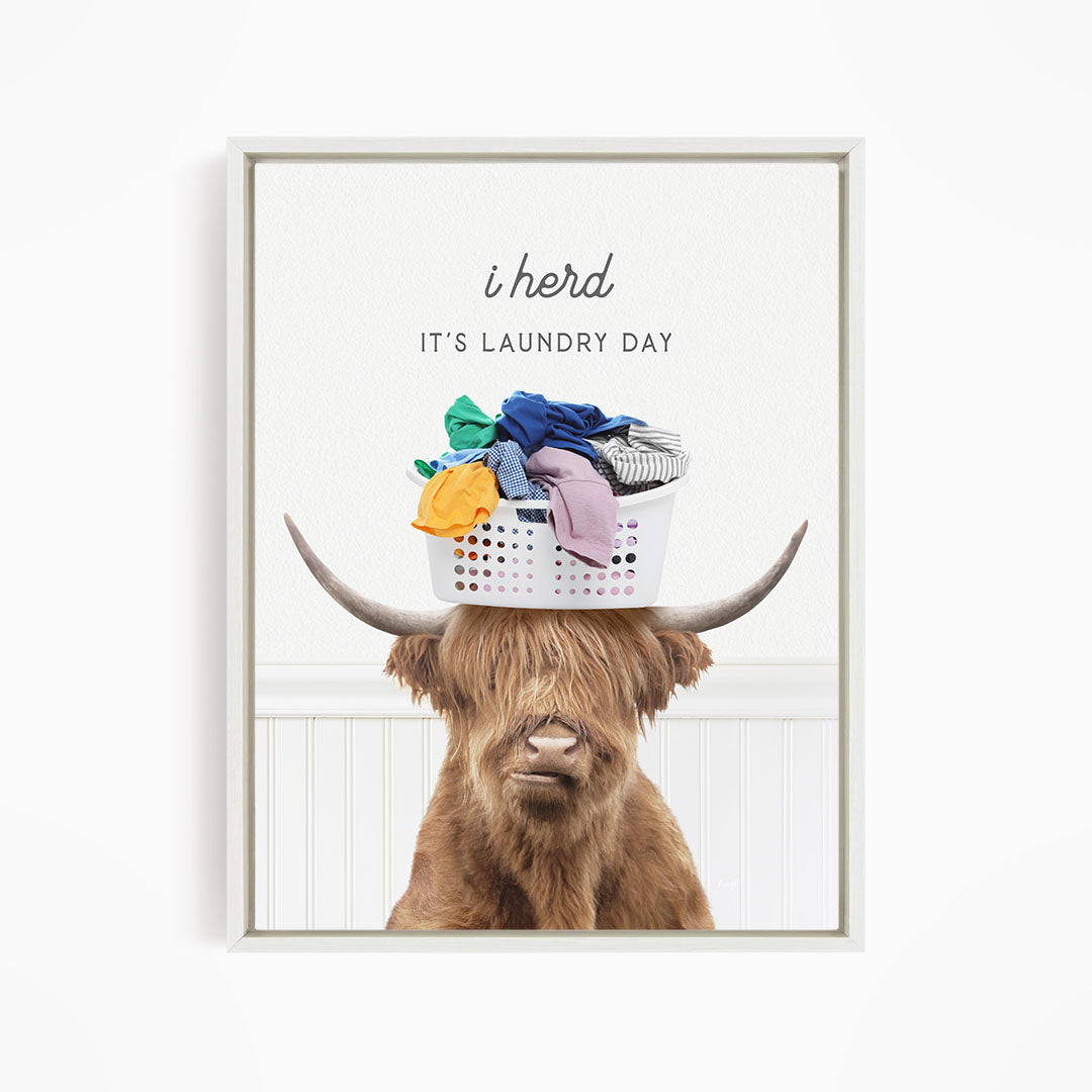 A brown cow with long hair is sitting in front of a white basket filled with clothes, with the text "It's laundry day" above the basket.
