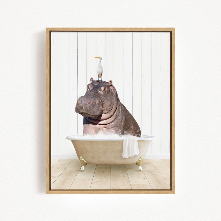 A framed image depicting a hippopotamus sitting in a bathtub, with a bird perched on its head.