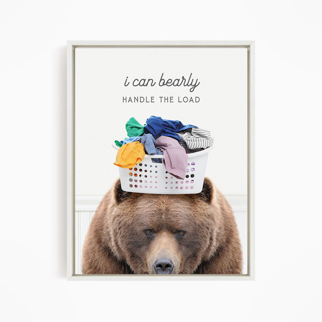 A brown bear sits in front of a laundry basket filled with clothes, with the text "I can bearly handle the load" written above the basket.