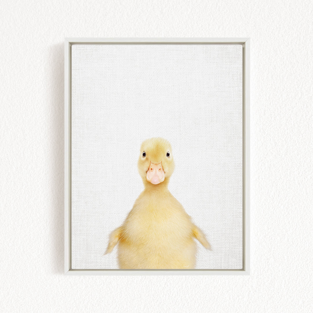 A cute yellow duck with a pink beak is standing in a white frame against a plain white background.