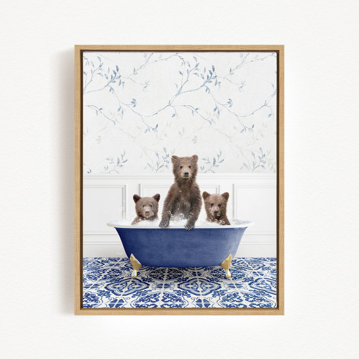 Three adorable brown bears sitting in a blue bathtub, with a floral patterned wall behind them.