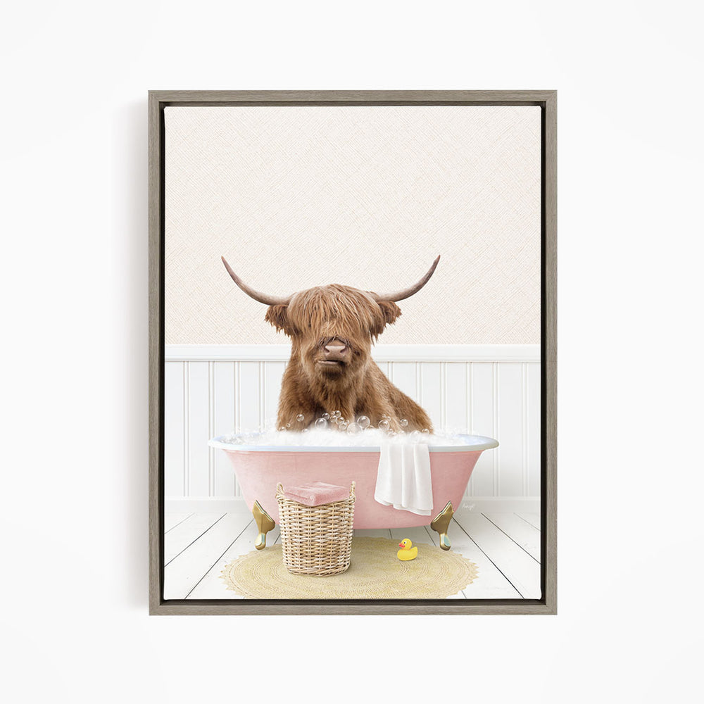 A brown cow with long horns is sitting in a pink bathtub filled with water, surrounded by a yellow rubber duck and a basket.