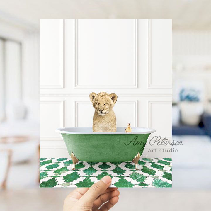 a hand holding a card with a picture of a baby lion in a bathtub