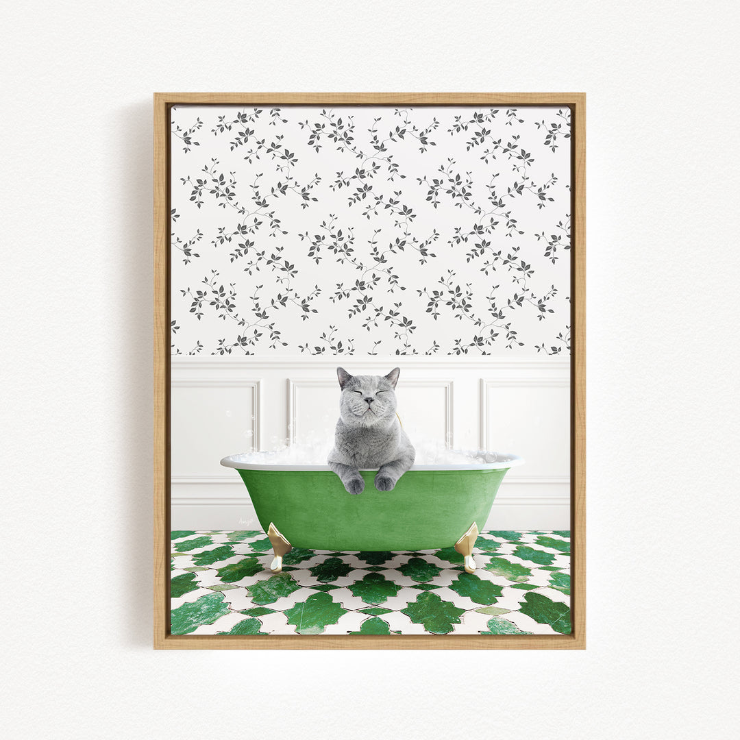 A gray cat sitting in a green bathtub filled with bubbles, with a patterned wall behind it.