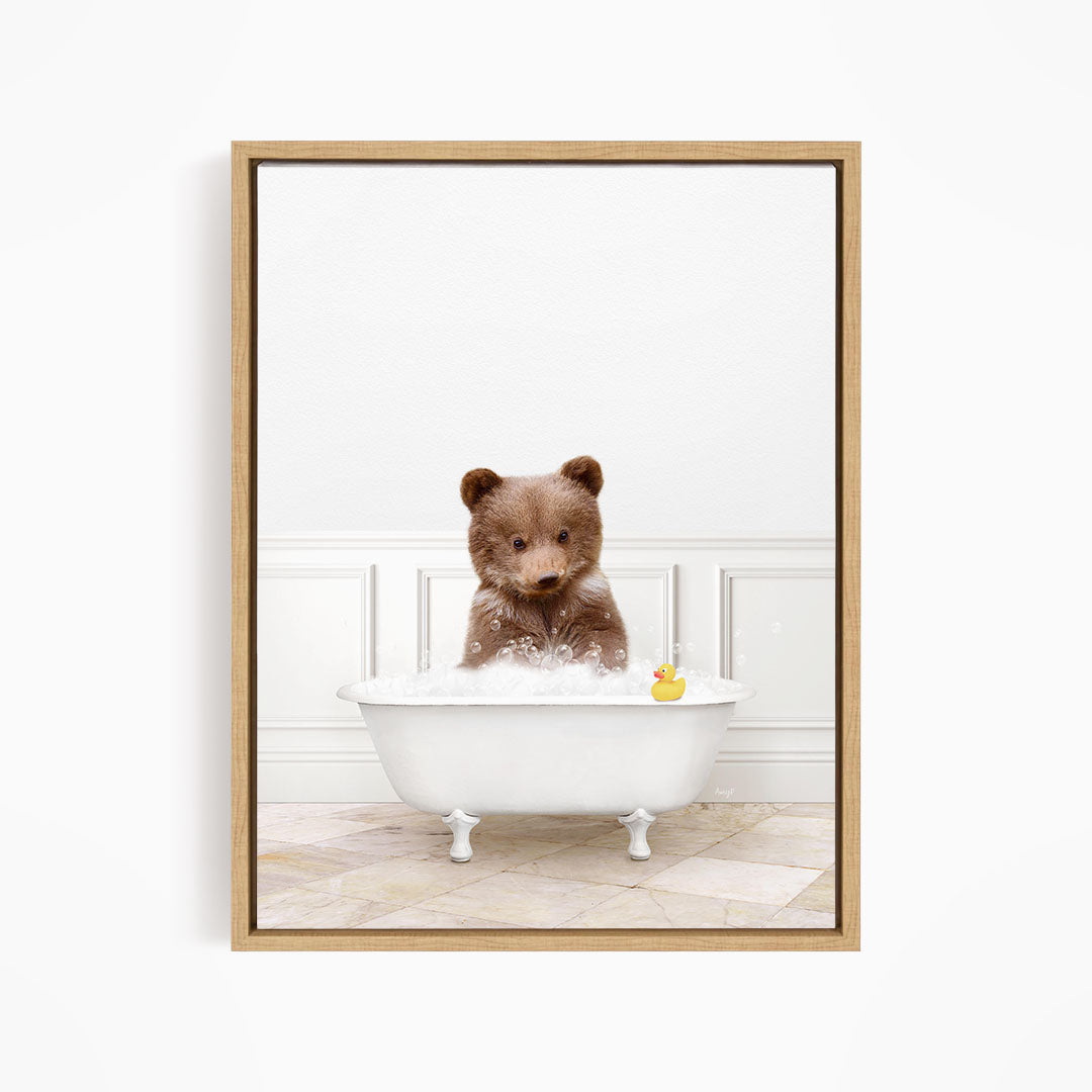 A brown bear sitting in a white bathtub filled with bubbles, with a rubber duck floating nearby.