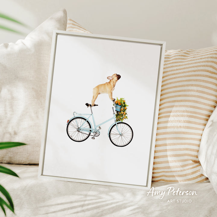 A framed illustration of a dog riding a bicycle, with a basket of flowers attached to the back.