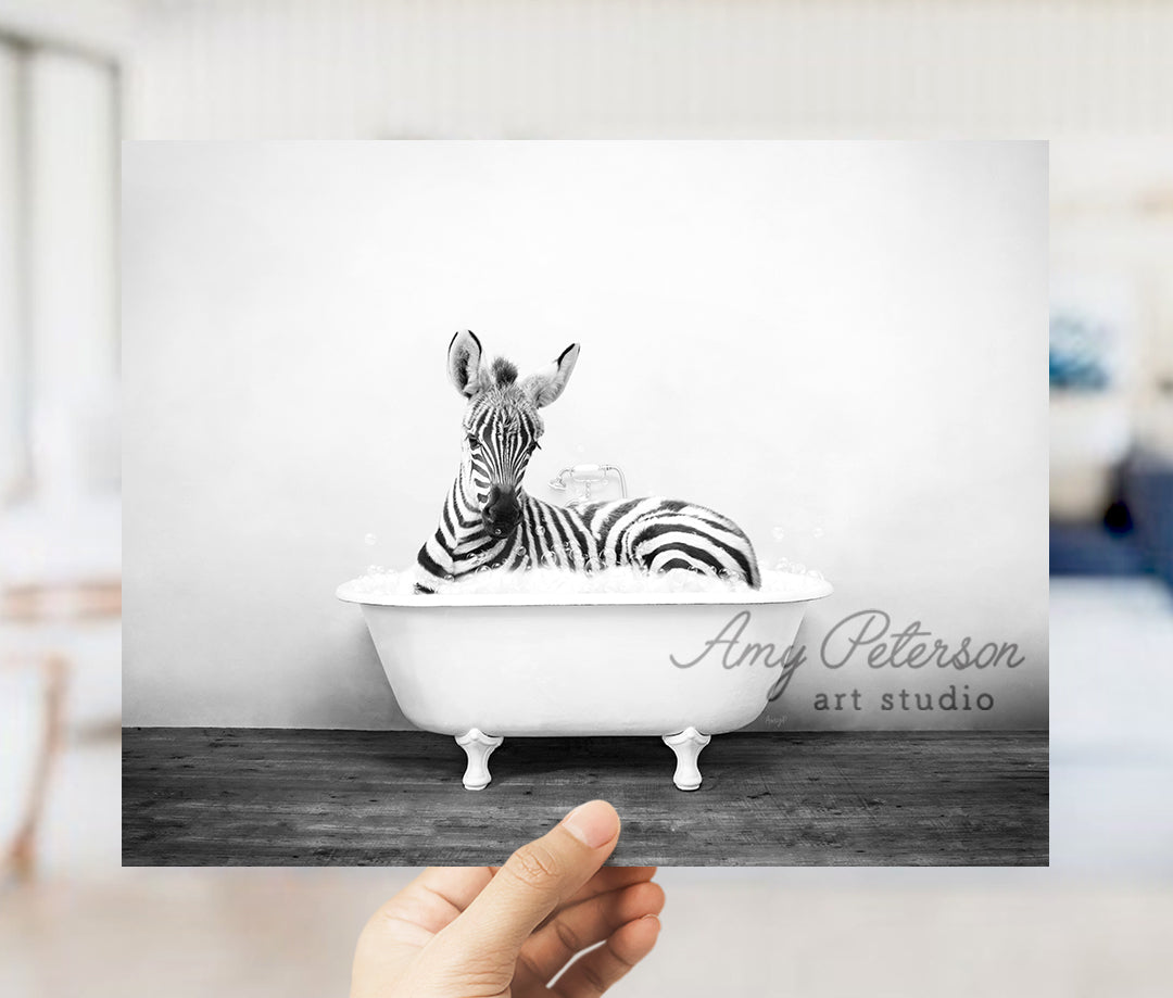 a person holding up a picture of a zebra in a bathtub