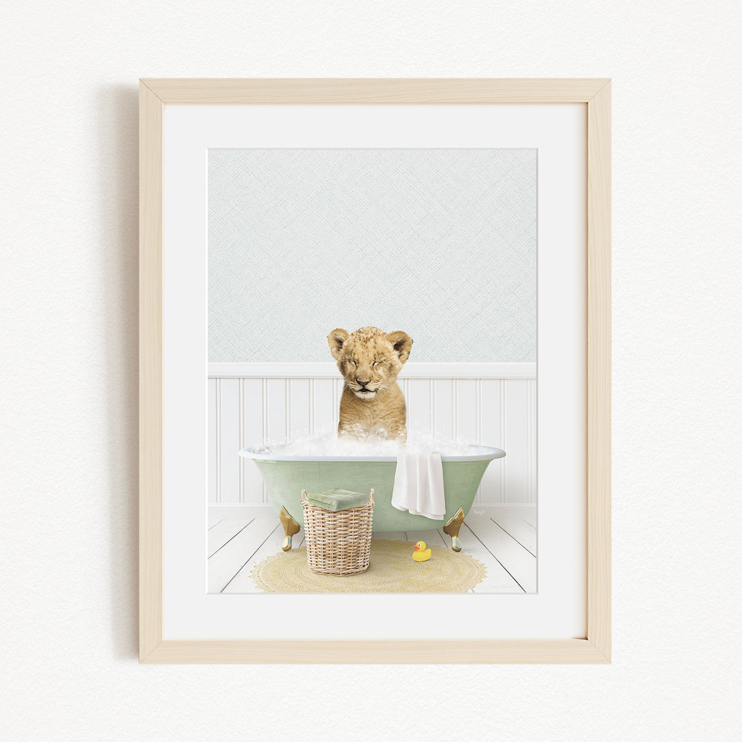 A young lion cub sitting in a green bathtub filled with water, surrounded by rubber ducks and a basket.