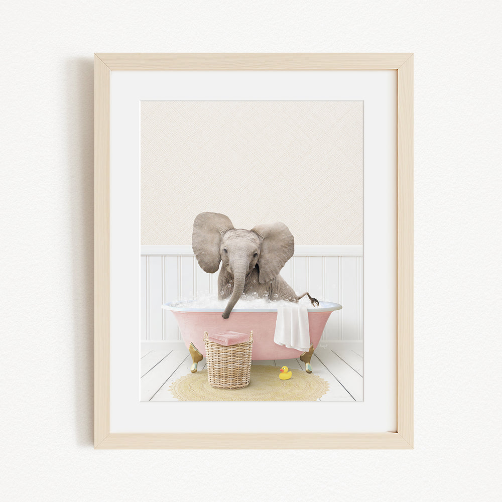 A baby elephant sitting in a pink bathtub, surrounded by a yellow rubber duck and a basket of toys.