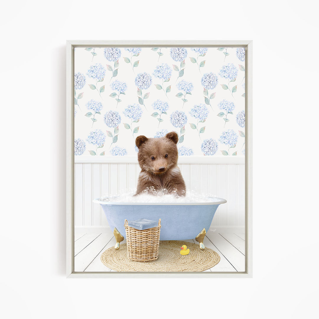 A brown bear sitting in a blue bathtub filled with water, surrounded by a wicker basket and a yellow rubber duck.