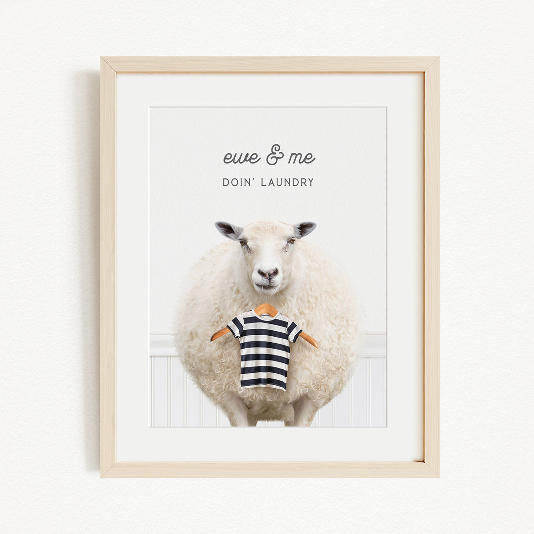 A framed image of a sheep wearing a striped shirt, with the text "eue & me DO'N Laundry" written above it.
