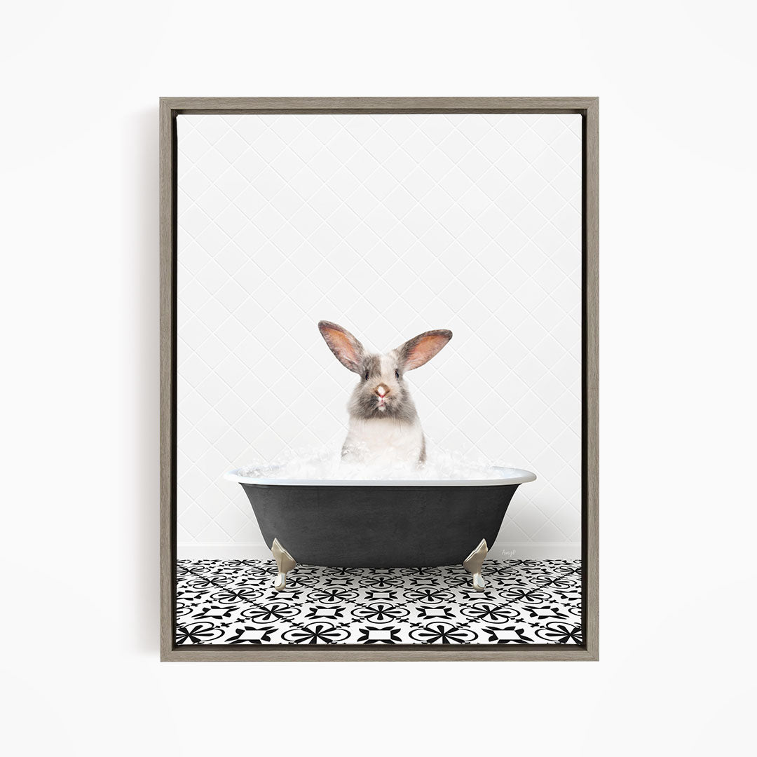 A white rabbit sitting in a black bathtub filled with water, looking directly at the camera.