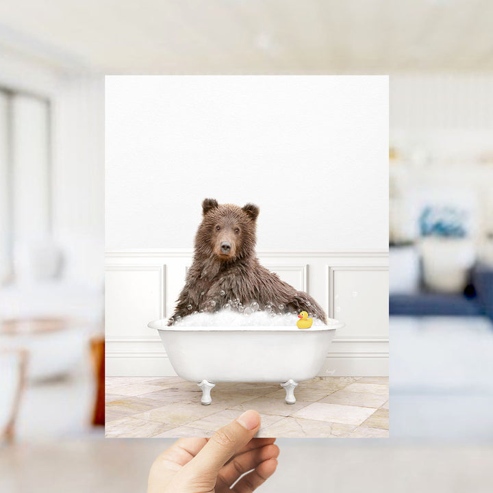A brown bear sitting in a white bathtub filled with bubbles, with a yellow rubber duck floating nearby.