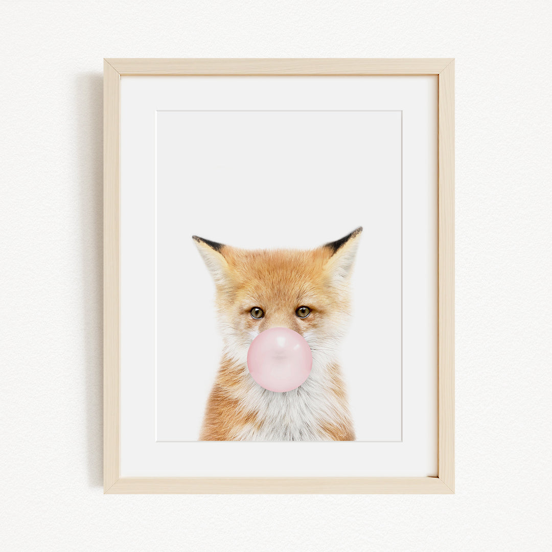 A framed image of a fox blowing a bubble with a pink bubble gum bubble.