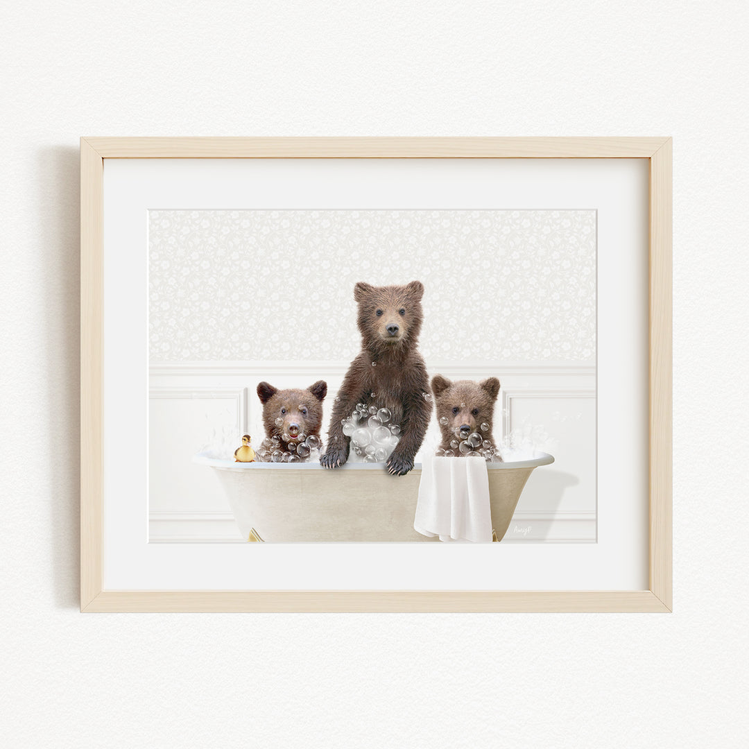 A framed image depicting three bears sitting in a bathtub, with one bear sitting on the edge of the tub and the other two bears sitting inside the tub.
