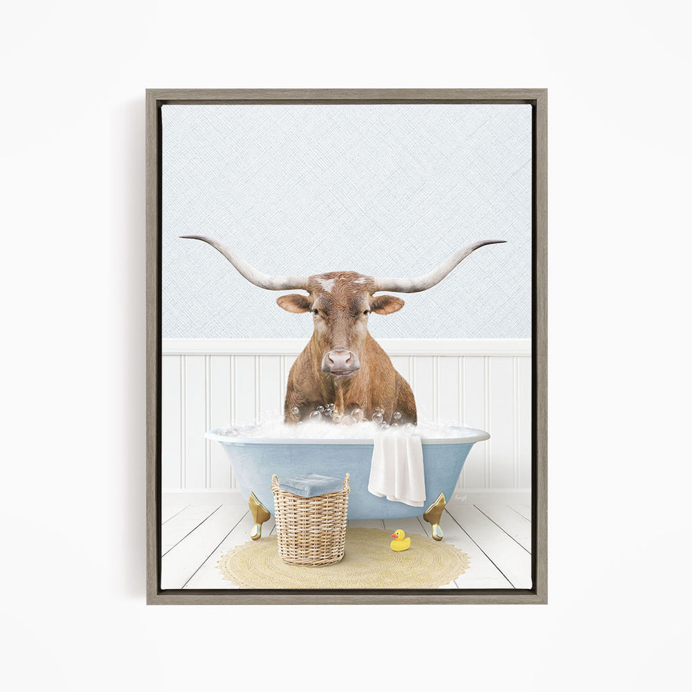 A brown bull with long horns is sitting in a blue bathtub filled with water, surrounded by a yellow rubber duck and a basket.