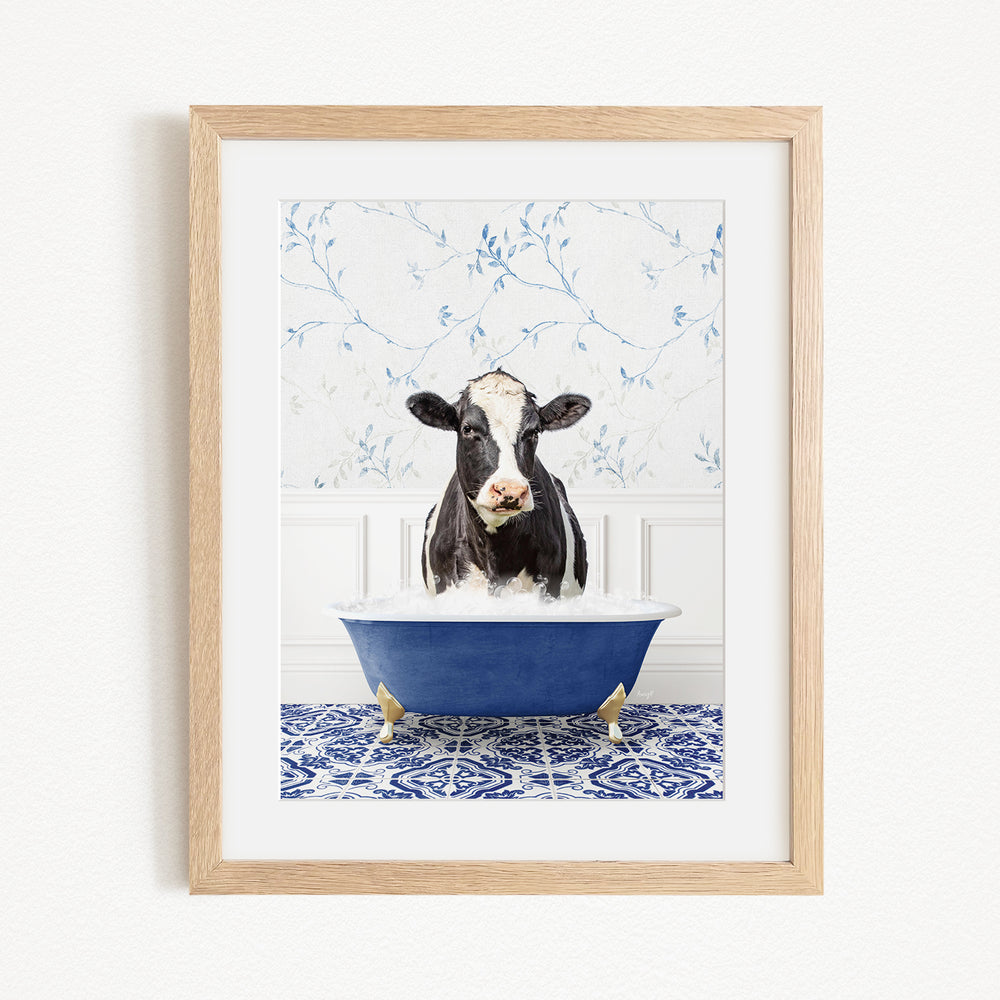 A black and white cow is sitting in a blue bathtub filled with water, creating a whimsical and humorous scene.