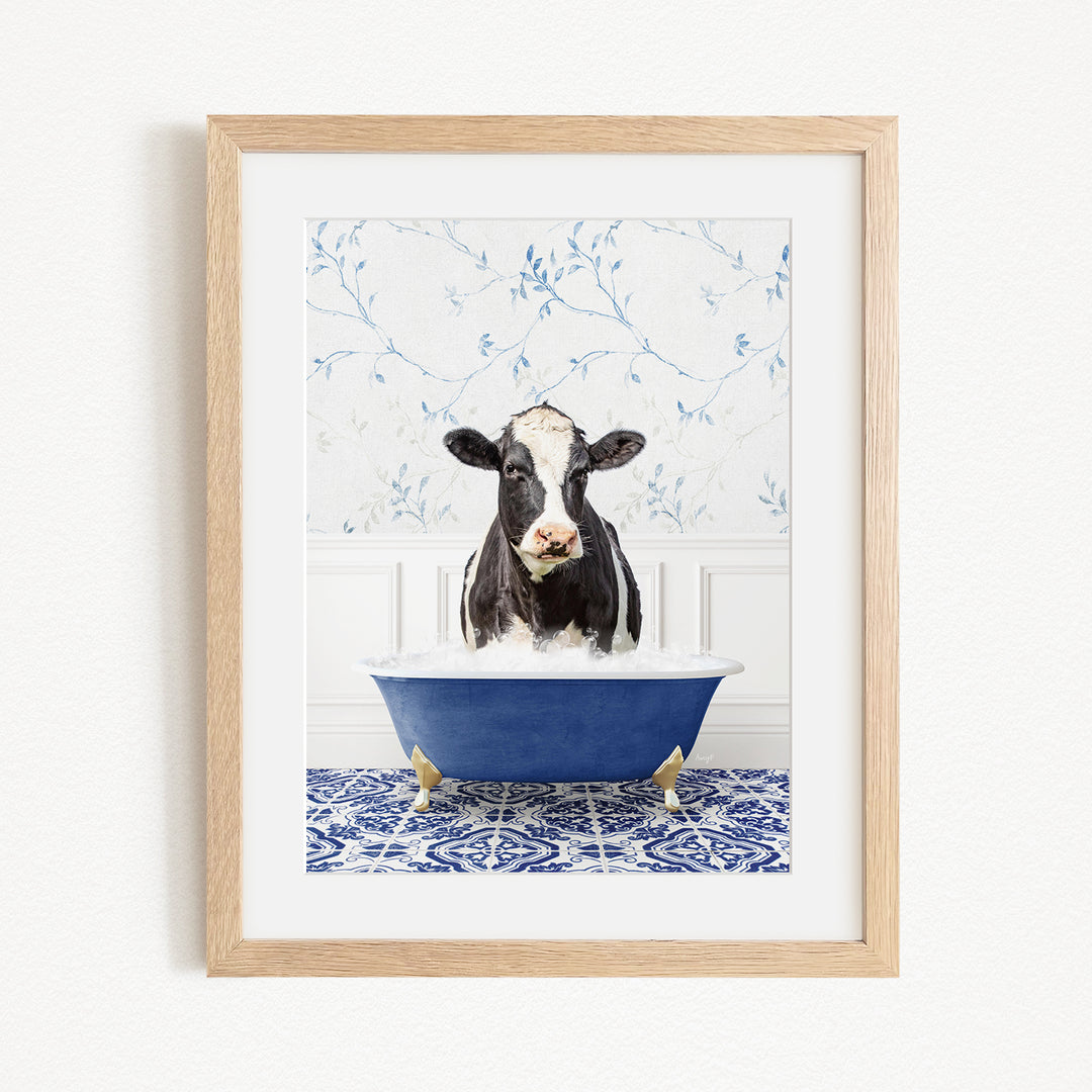 A black and white cow is sitting in a blue bathtub filled with water, creating a whimsical and humorous scene.