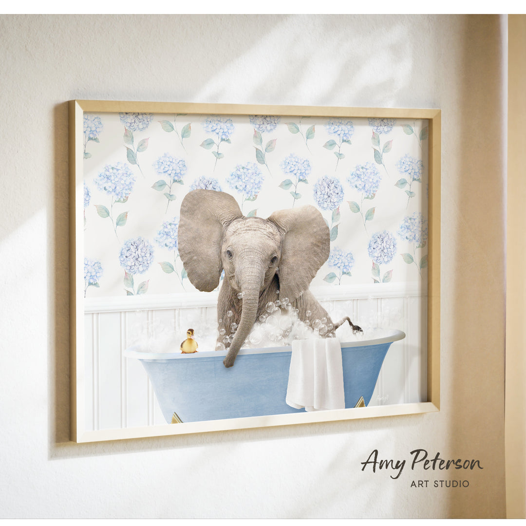 A framed image of an elephant sitting in a bathtub filled with bubbles, surrounded by a floral pattern.