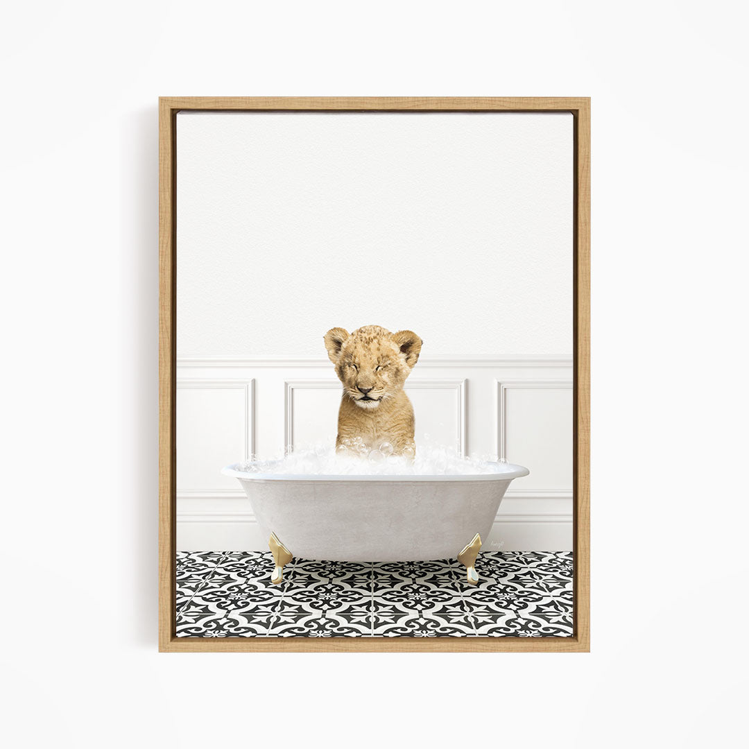 A young lion cub sitting in a white bathtub filled with water, surrounded by a black and white patterned floor.