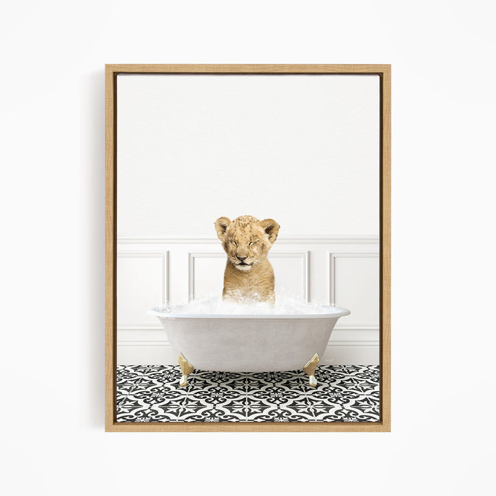 A young lion cub sitting in a white bathtub filled with water, surrounded by a black and white patterned floor.