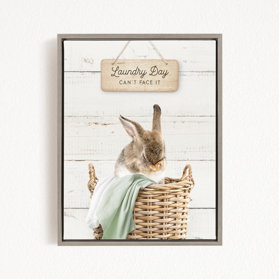 A cute rabbit sitting in a wicker basket, with a wooden sign above that says "Laundry Day Can't Face It".