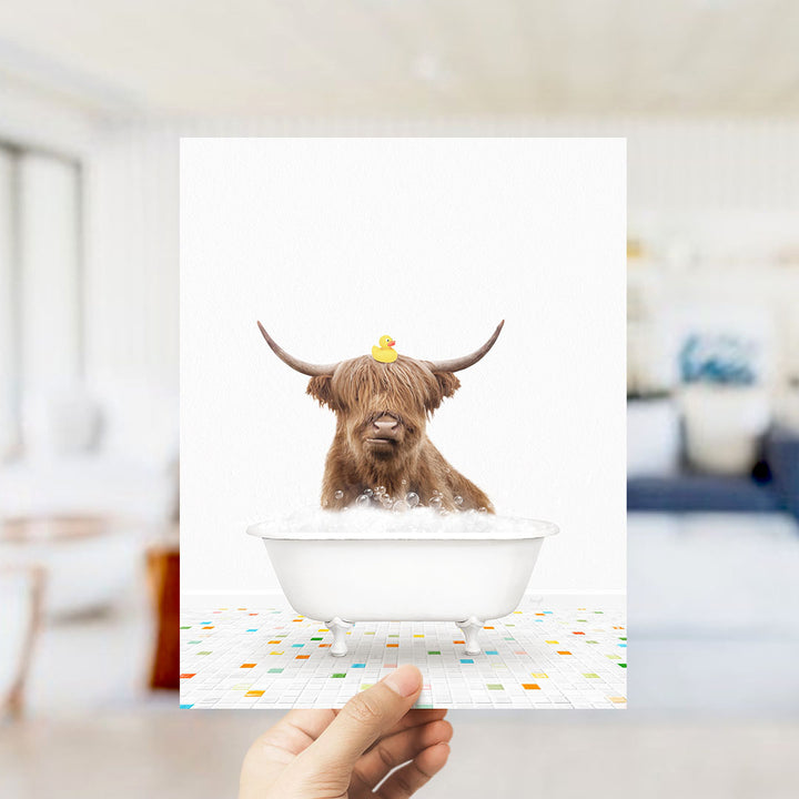 A brown cow with horns is sitting in a white bathtub filled with bubbles, with a rubber duck perched on its head.